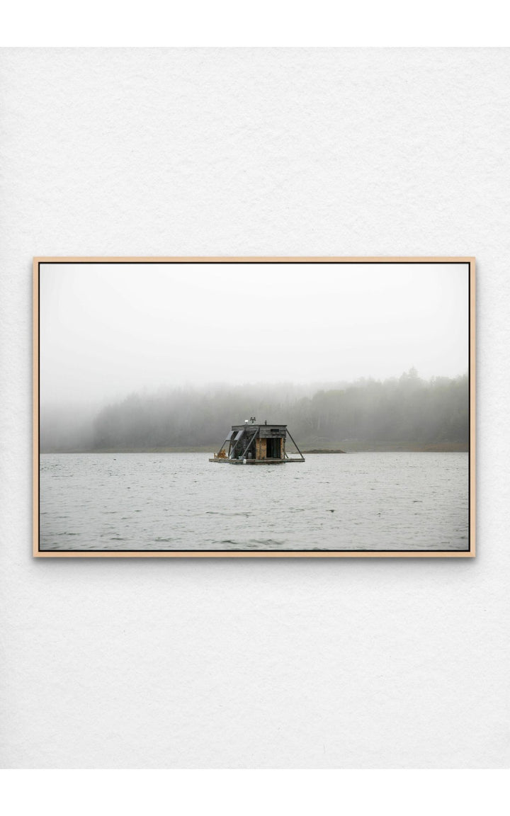 Photograph pf houseboat floating on a foggy Maine lake.
