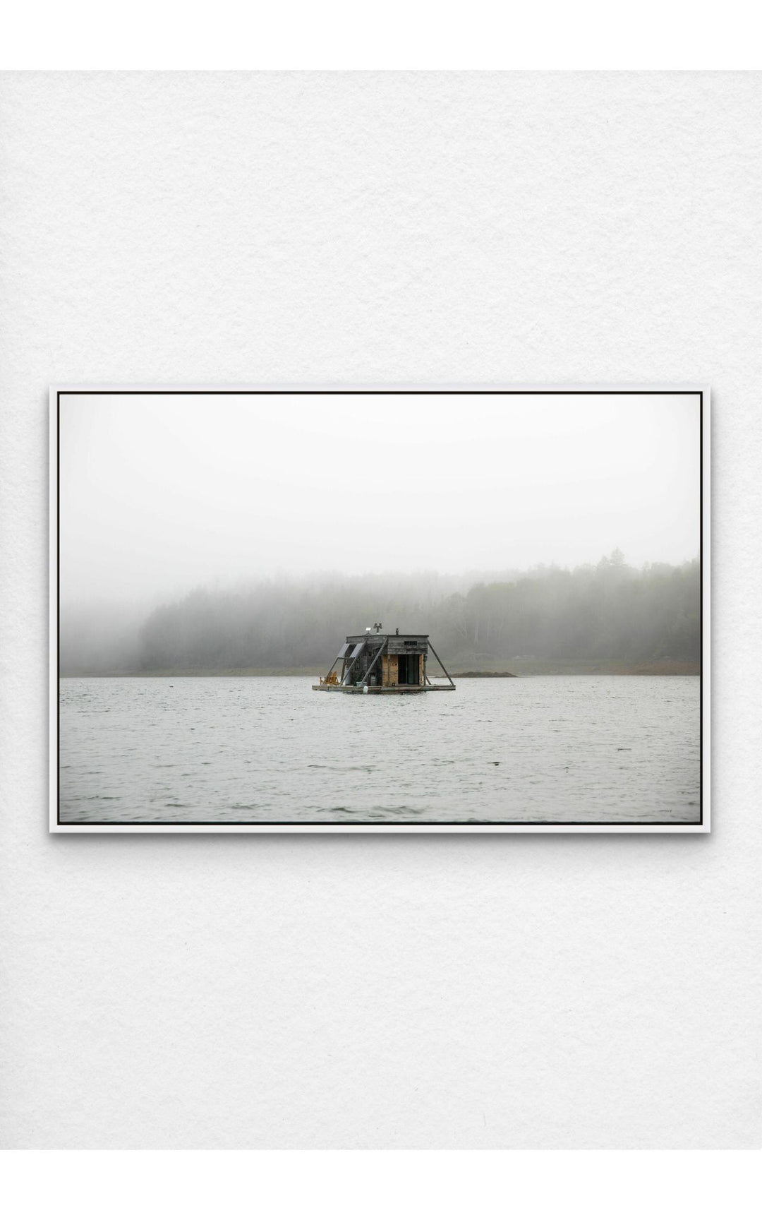 Photograph pf houseboat floating on a foggy Maine lake.
