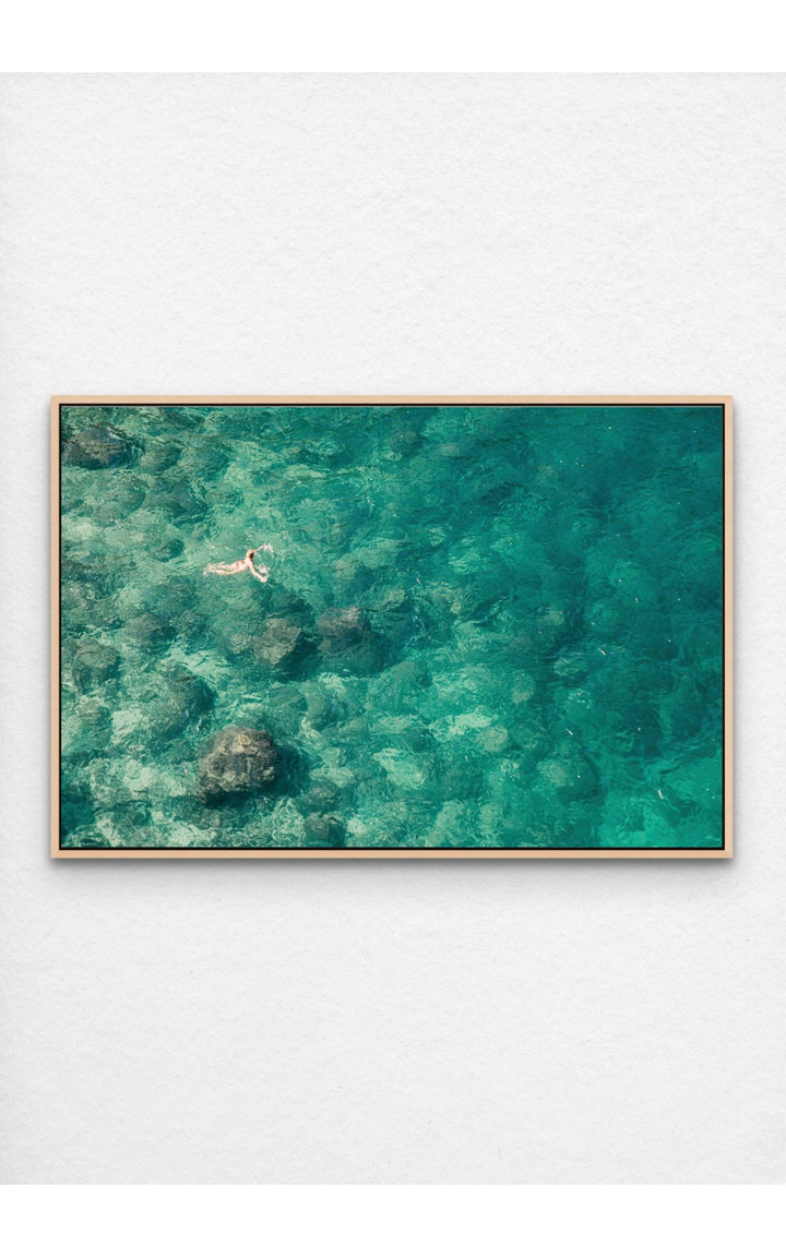 Lone swimmer in vibrant turquoise waters.
