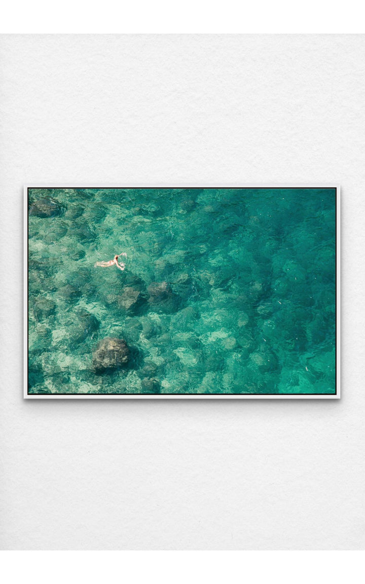 Lone swimmer in vibrant turquoise waters.