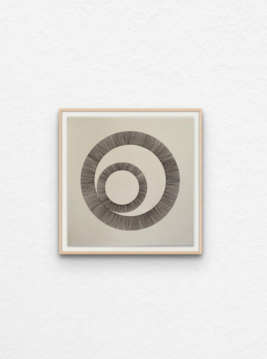 Ink drawing using lines to create two interlinked circles floated in maple frame,