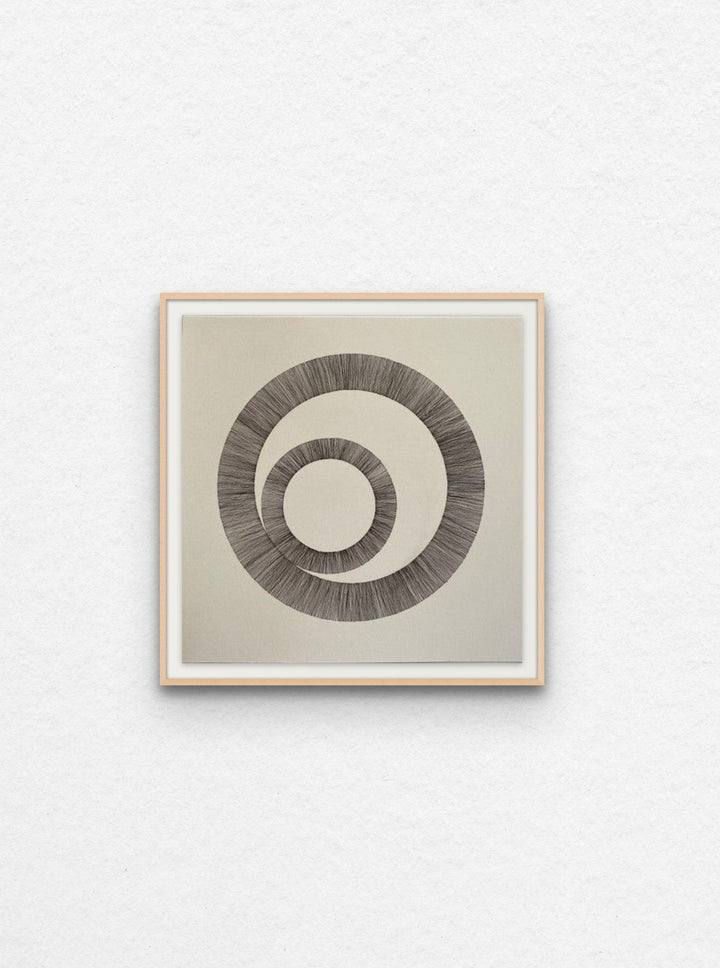 Ink drawing using lines to create two interlinked circles floated in maple frame,