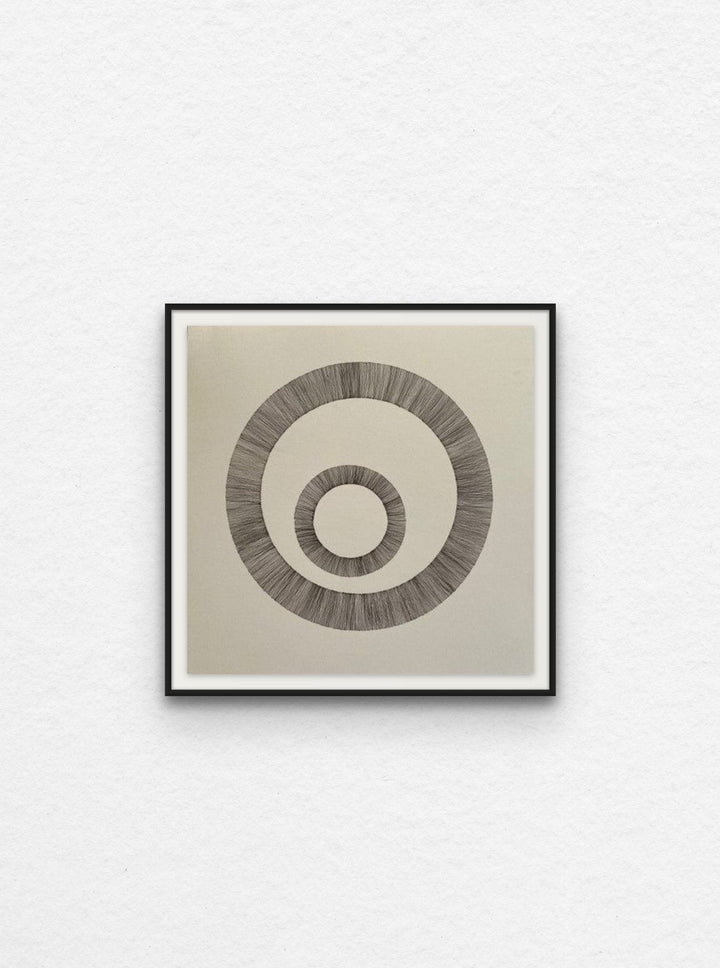 Ink artwork with two circles on paper floated in black frame.
