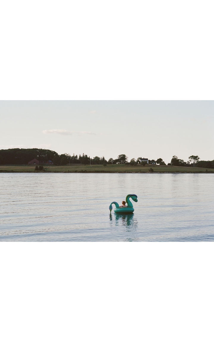 Woman on an inflatable float in the serene waters of Maine.