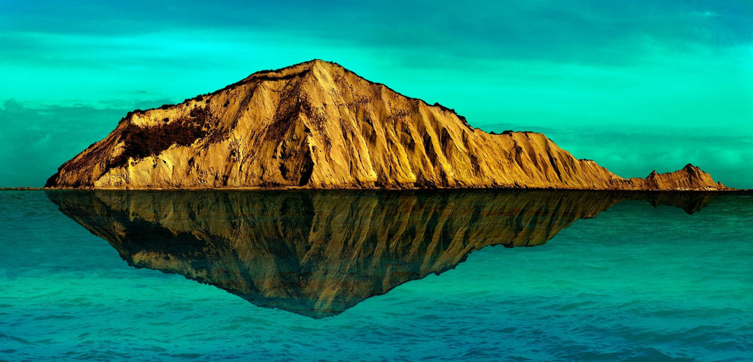 Motu-o-kura island with crystal clear reflection in the Pacific Ocean.