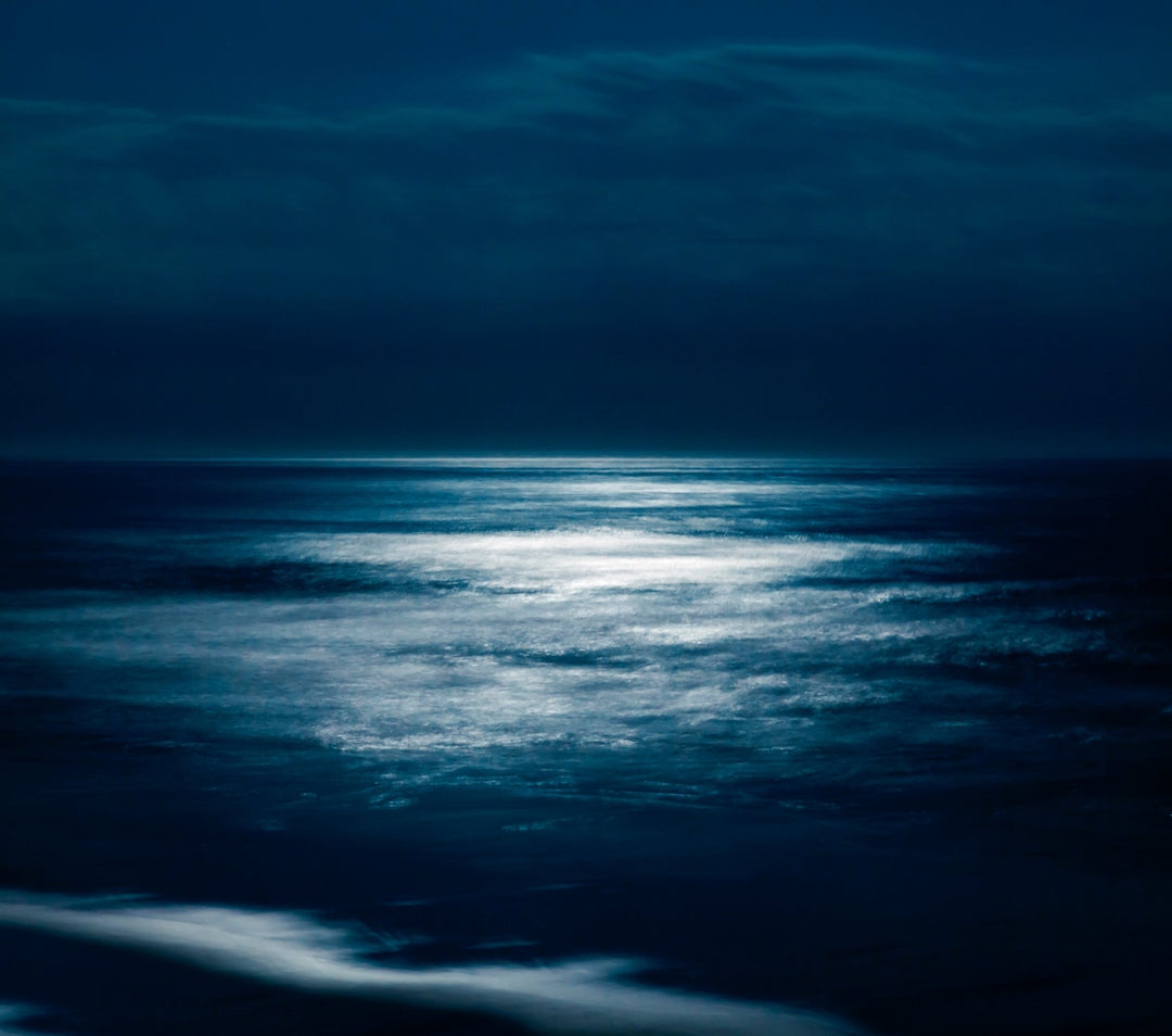 Moonlight reflecting on calm Pacific Ocean waters.