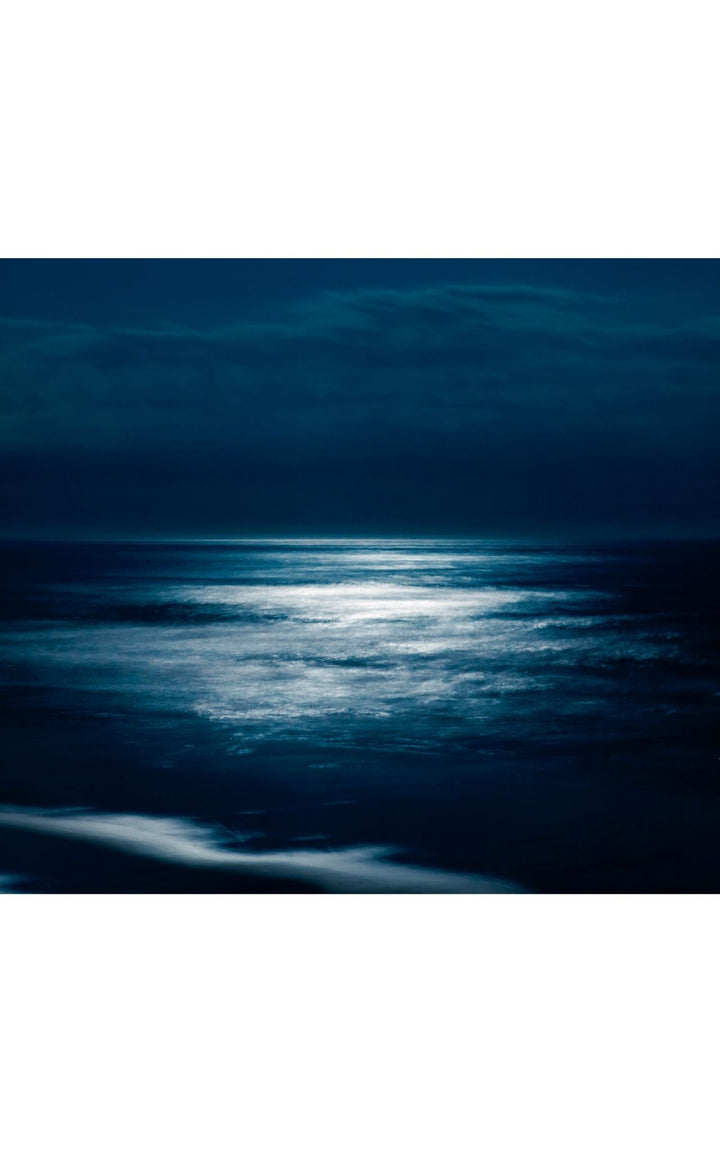 Moonlight reflecting on calm Pacific Ocean waters.