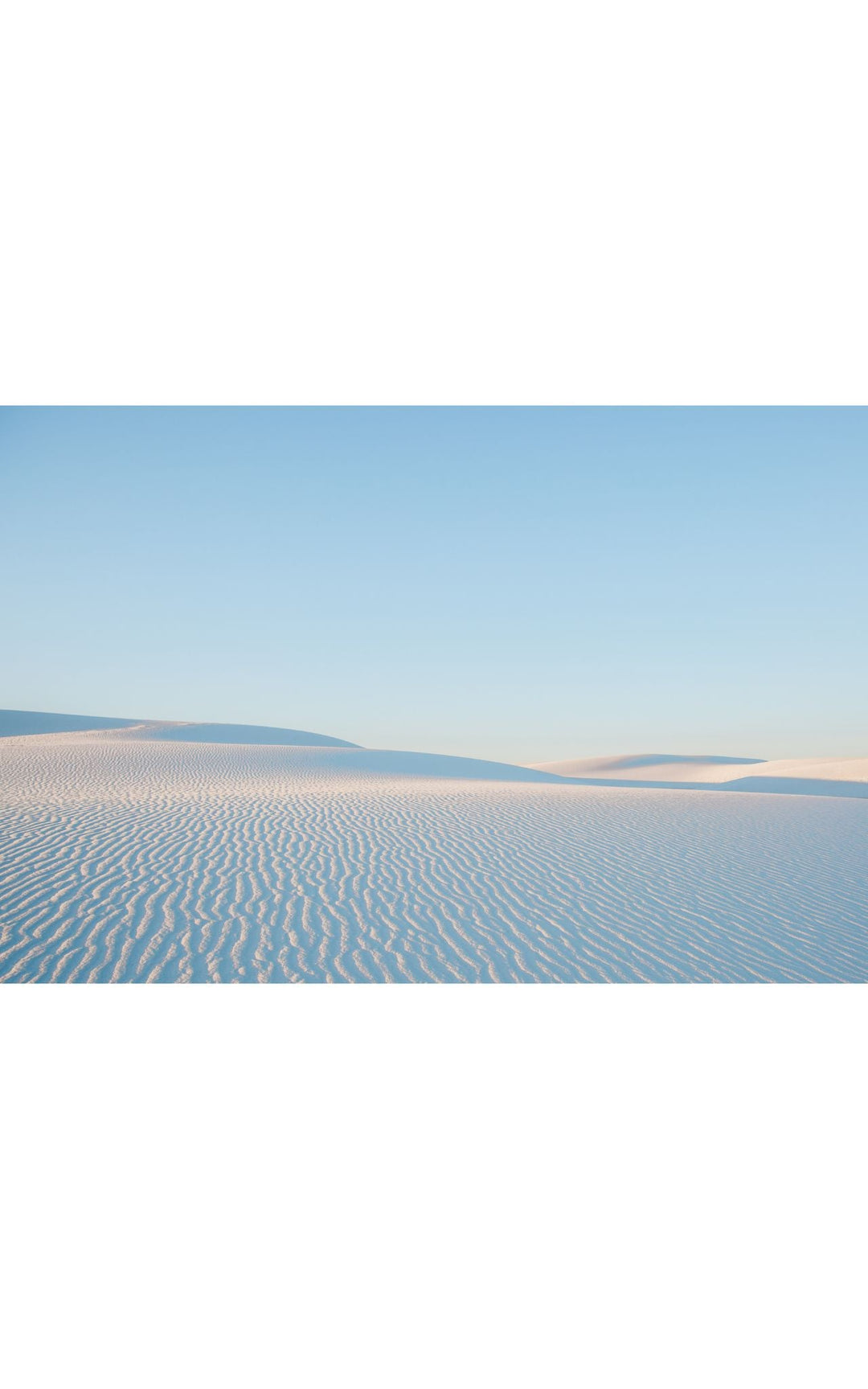 Soft ripples in the pristine dunes of White Sands, NM under a pastel sky.