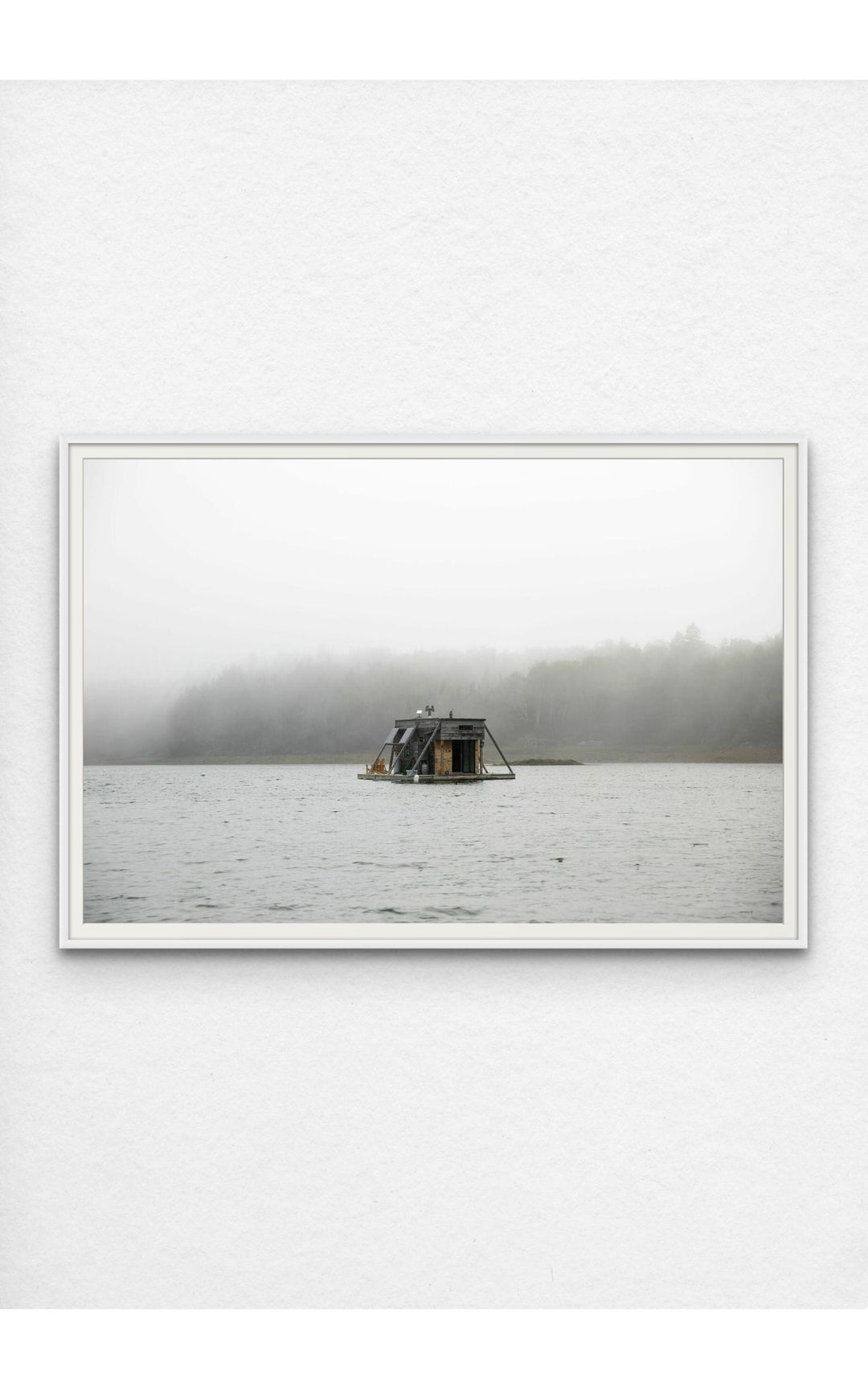 Photograph pf houseboat floating on a foggy Maine lake.