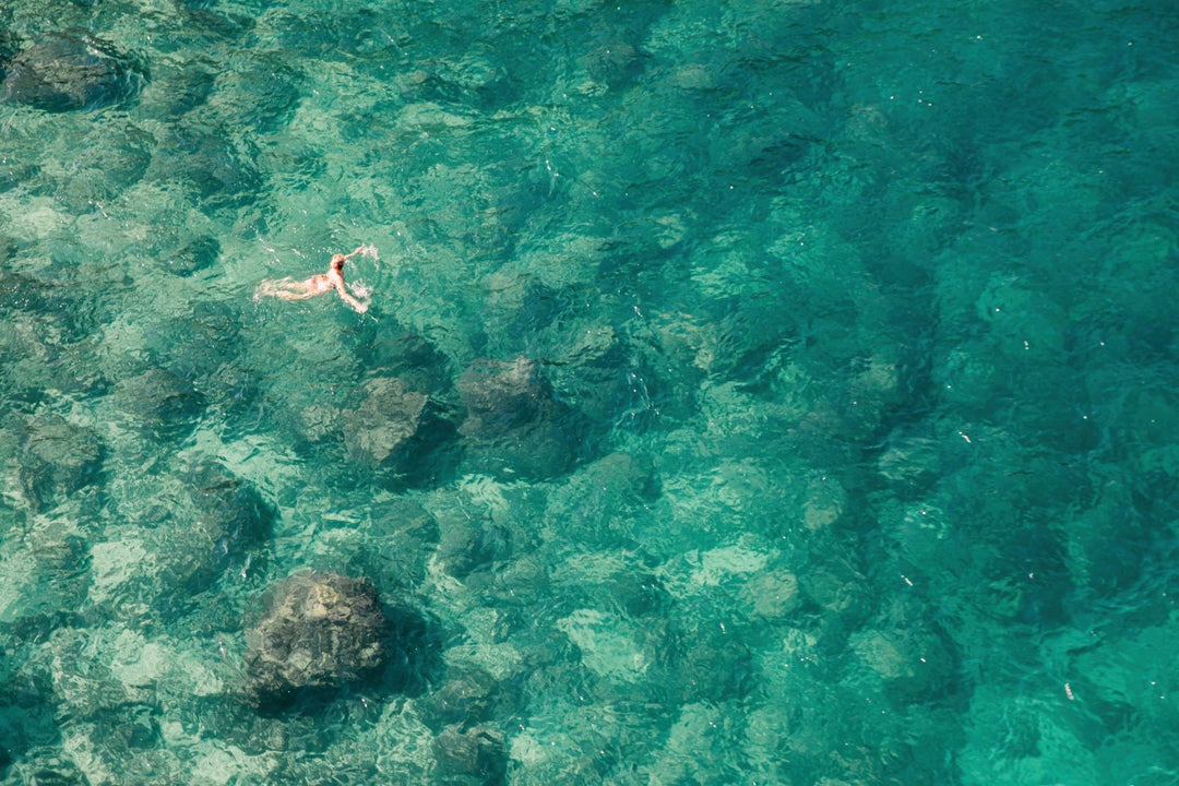 photograph of a swimmer in an emerald sea