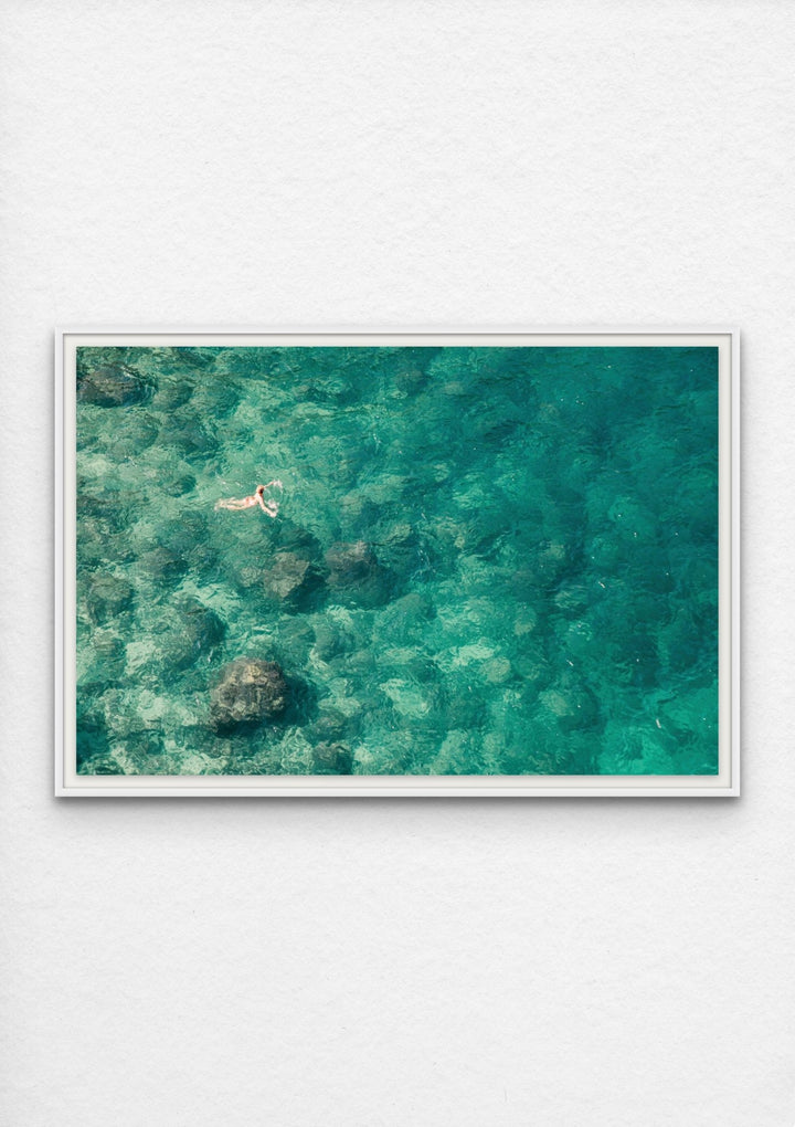 photograph of a swimmer in an emerald sea