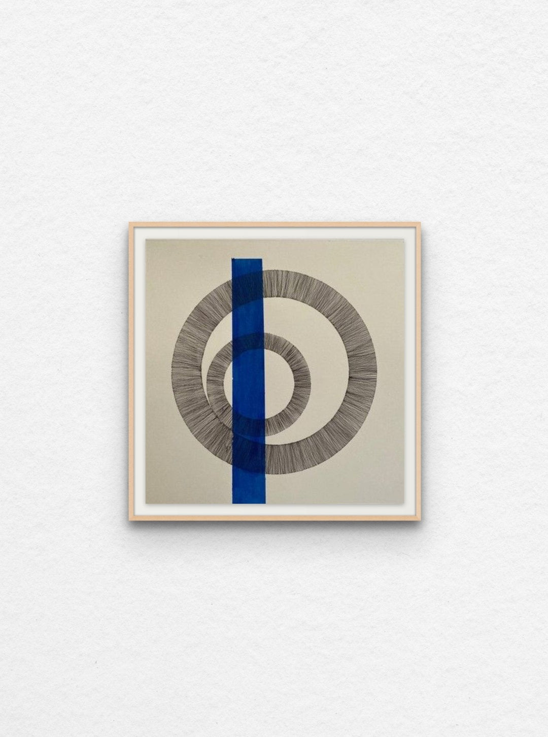 Ink drawing of two circles on paper with blue acrylic shape floated in maple frame. 