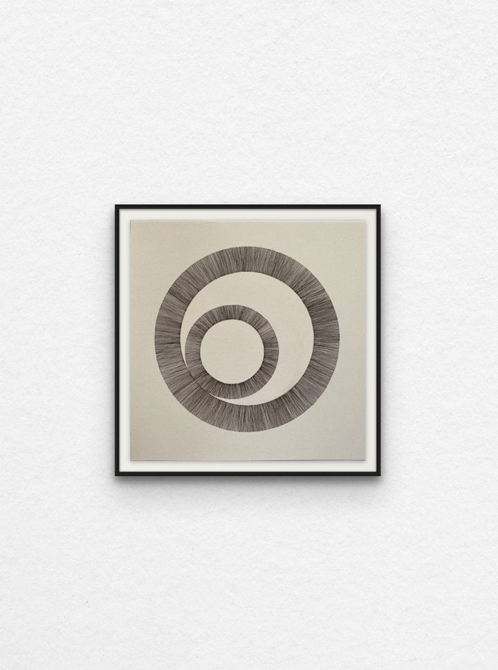Ink drawing using lines to create two interlinked circles floated in black frame,